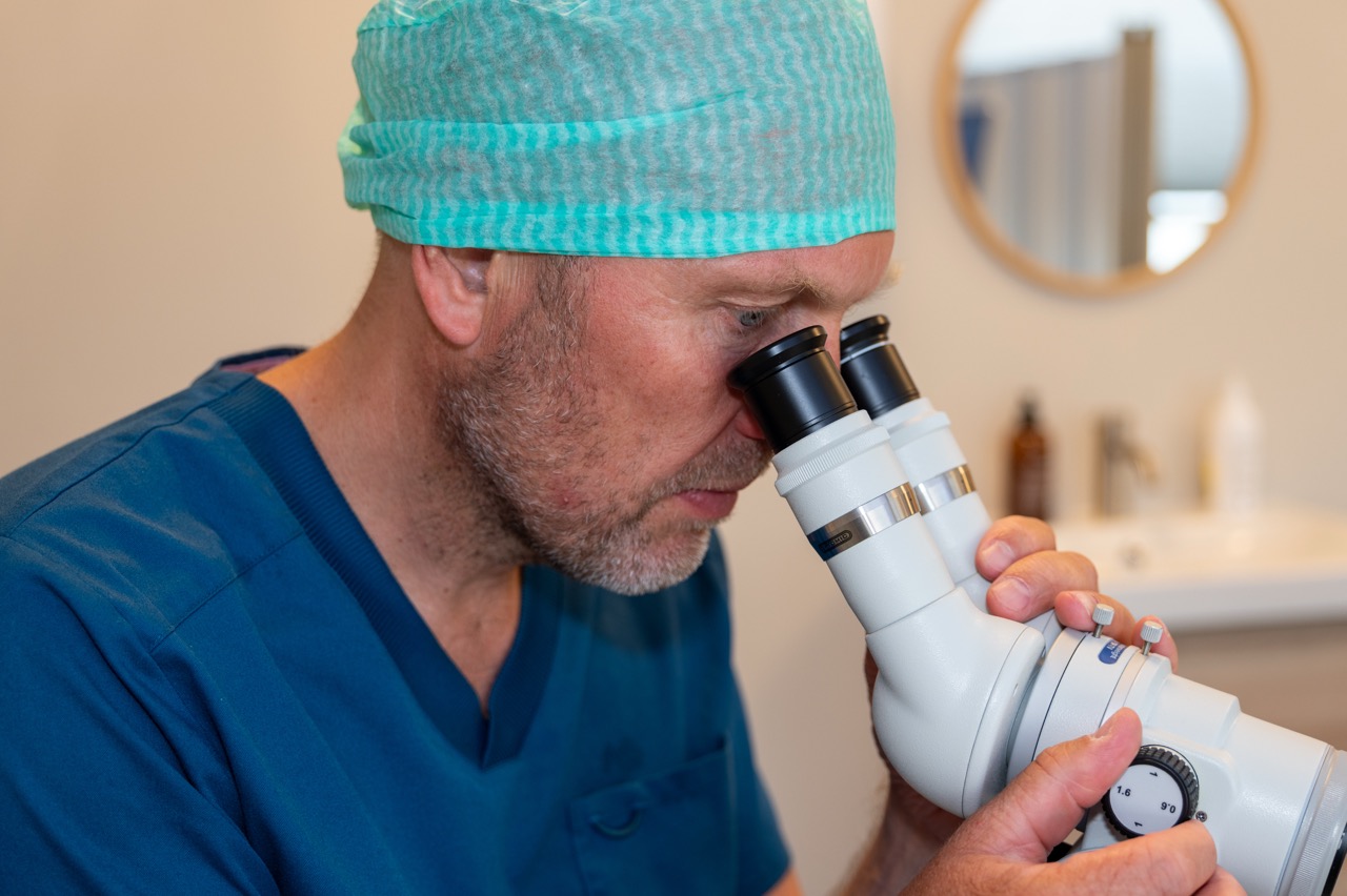 Gynekolog som titter i mikroskop